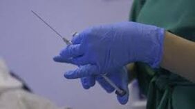 Jeringa en manos de un médico